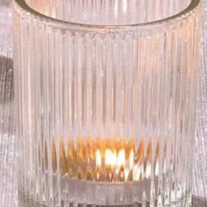 Ribbed glass candle holder, glowing flame