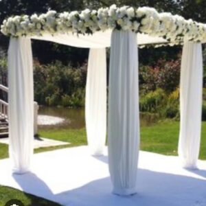 White floral wedding arch outdoors