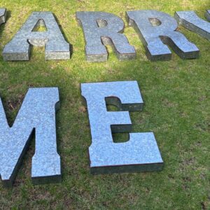Metal letters spelling marry me