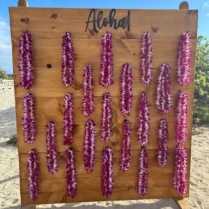 Floral leis hanging on wooden board